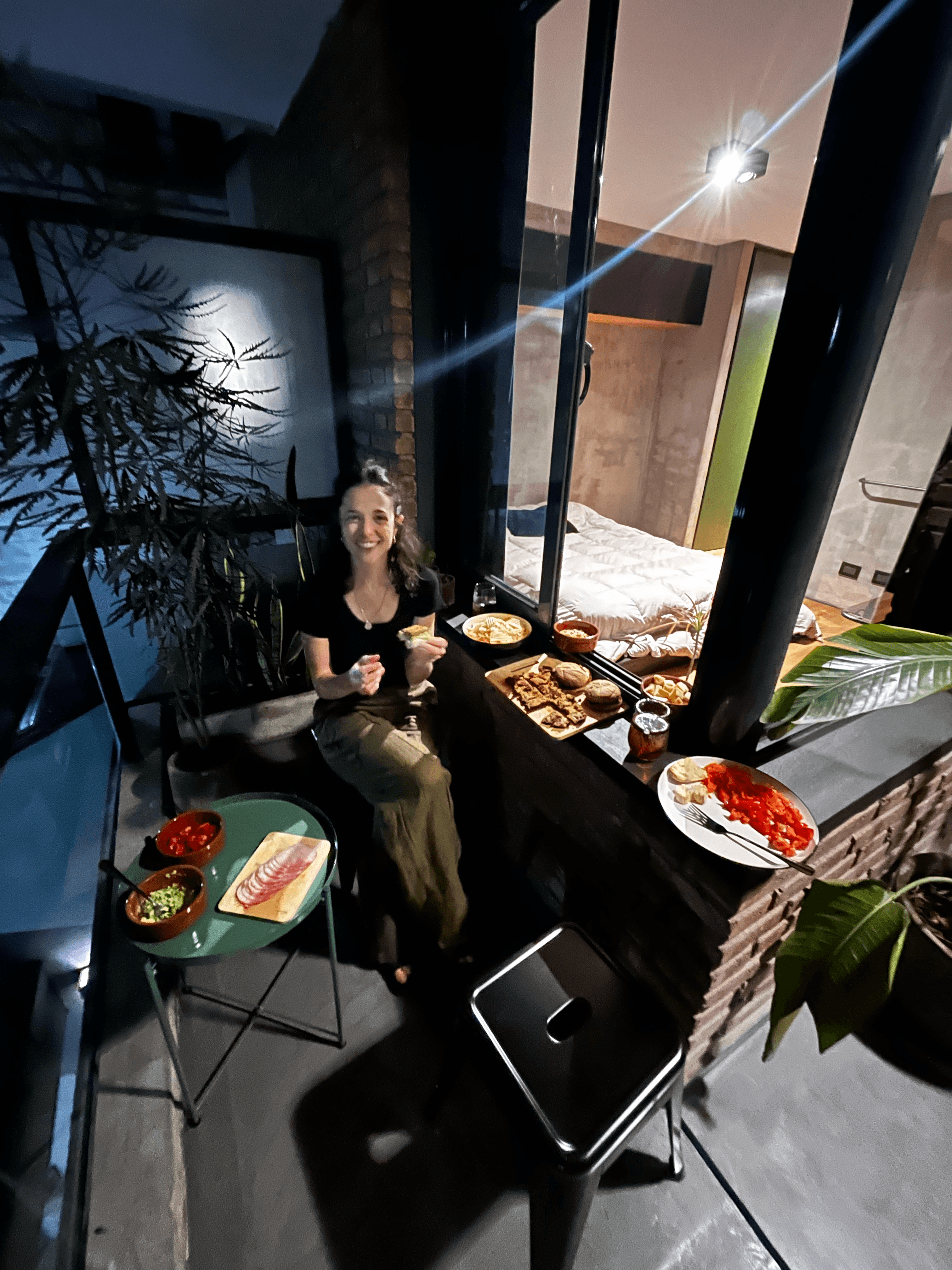 Balcón de noche con picadita y gente compartiendo