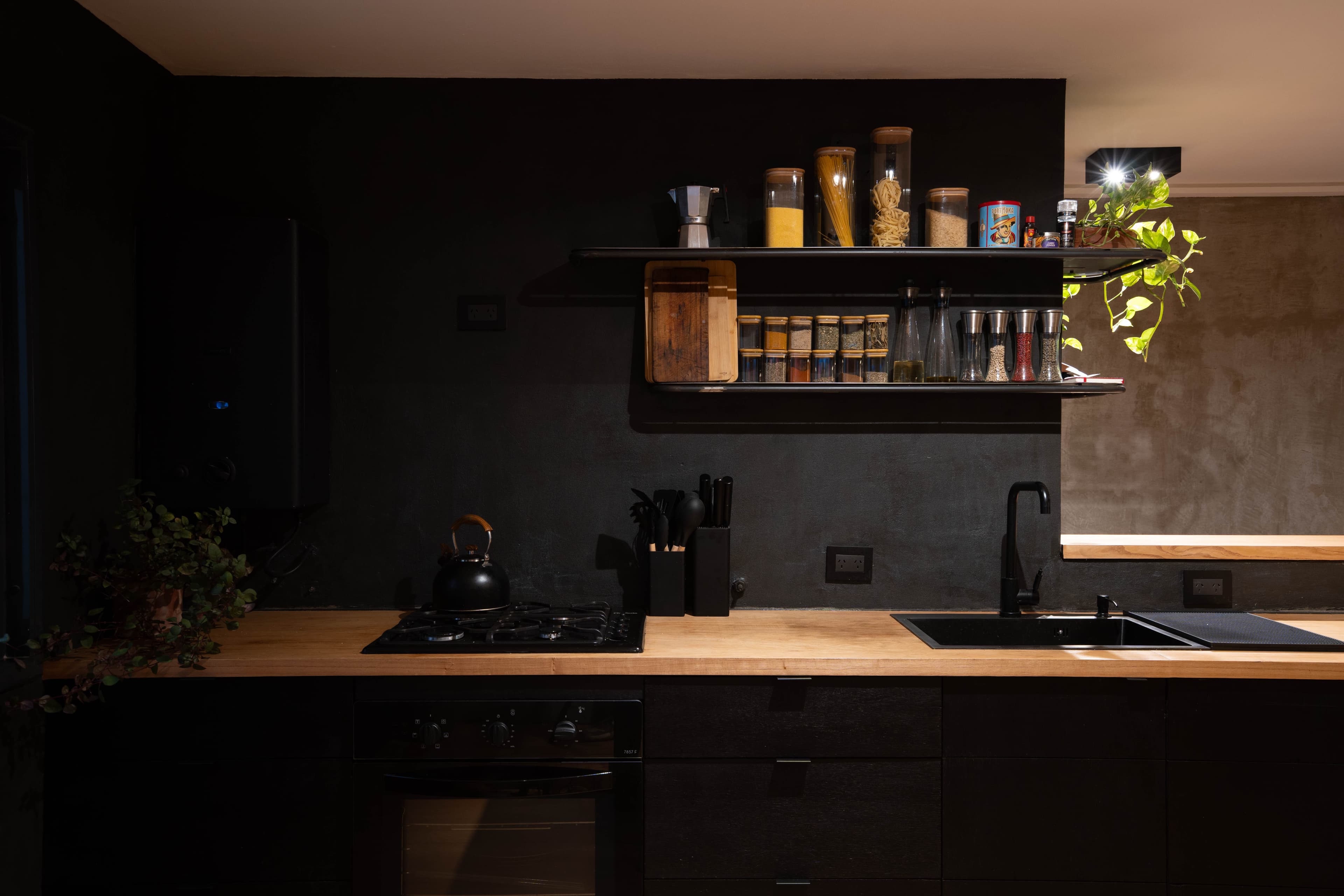 Cocina de noche con iluminación cálida y estanterías