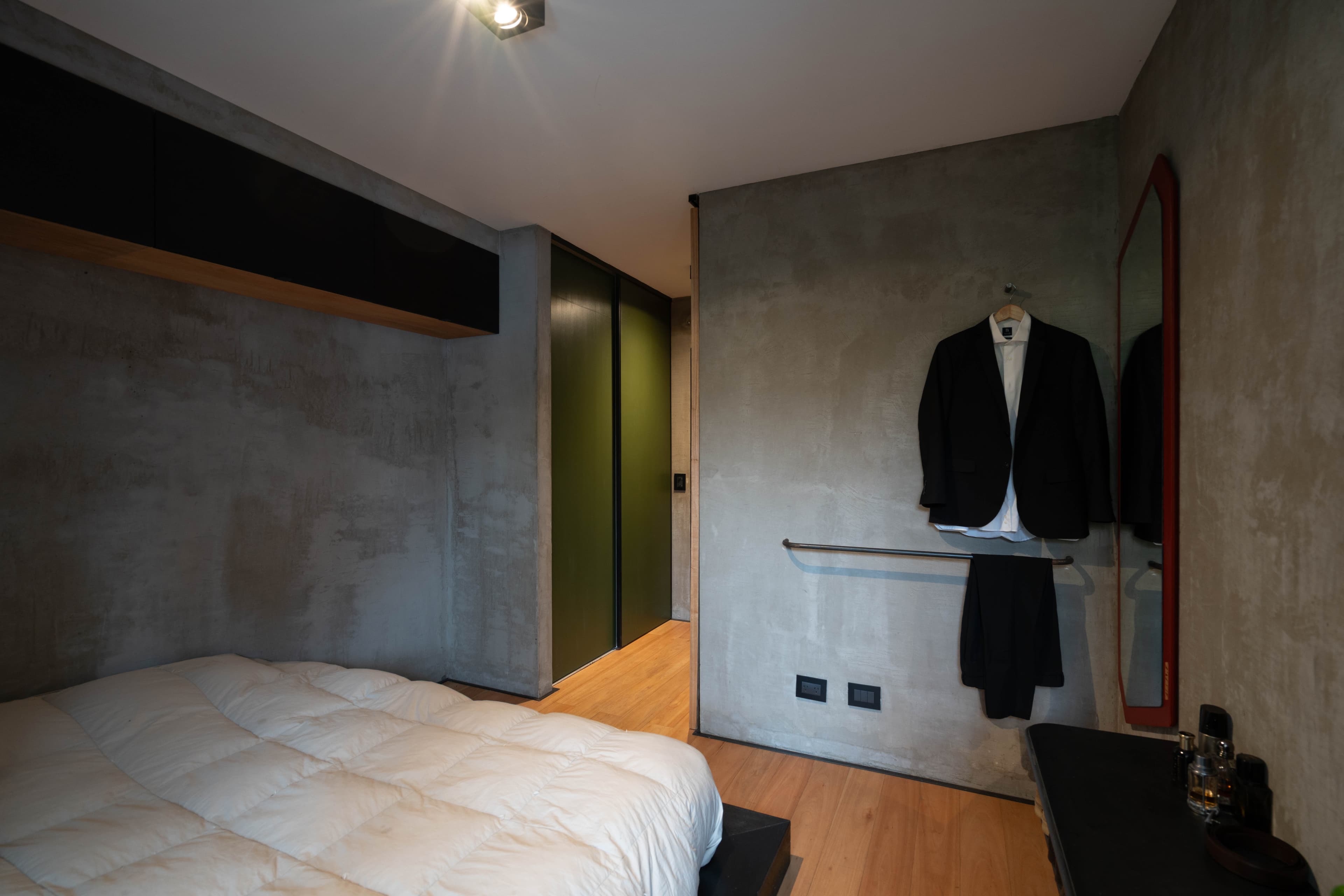 Habitación con placard verde, perchero y espejo de marco rojo