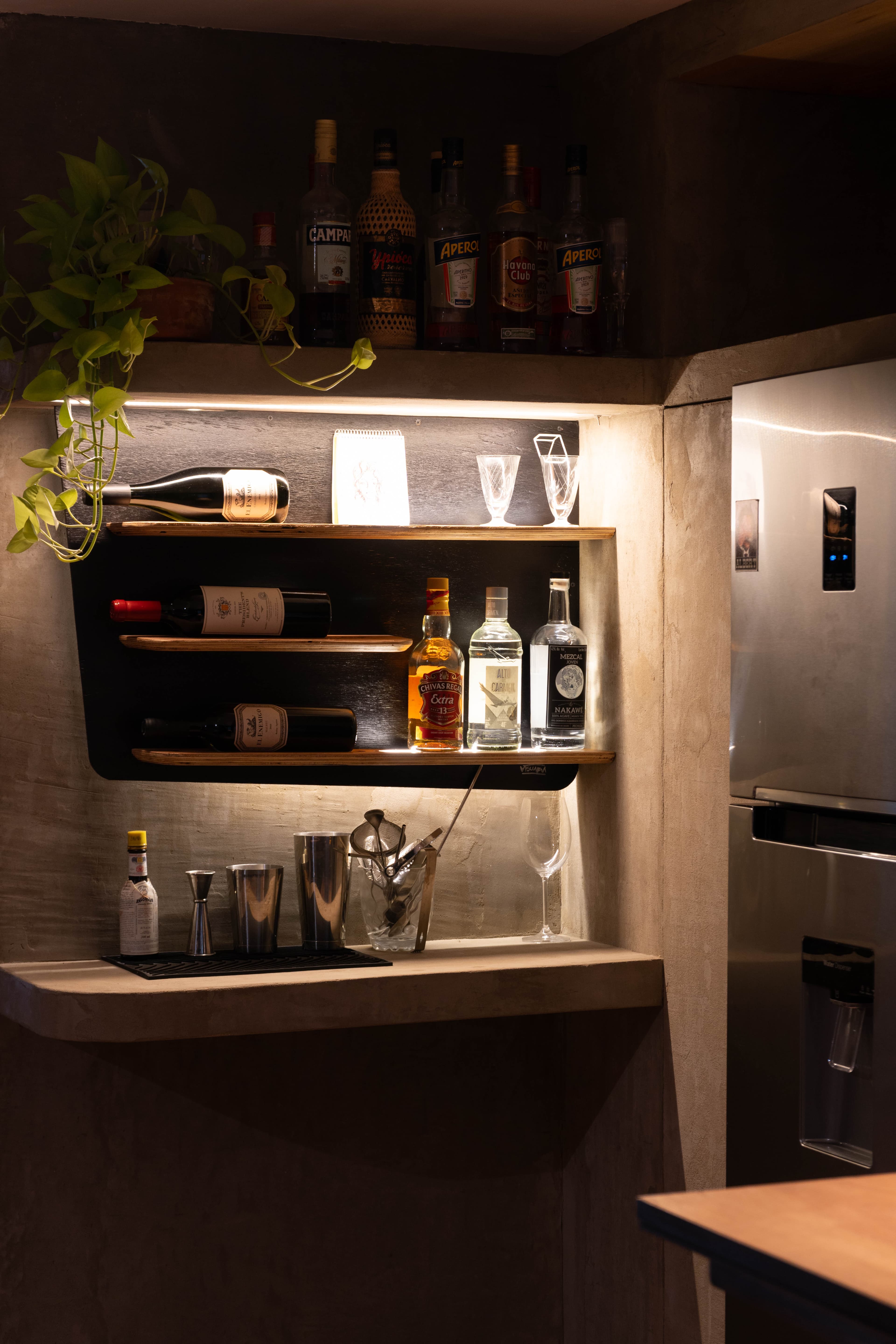 Zona de coctelería con estanterías iluminadas y vinos